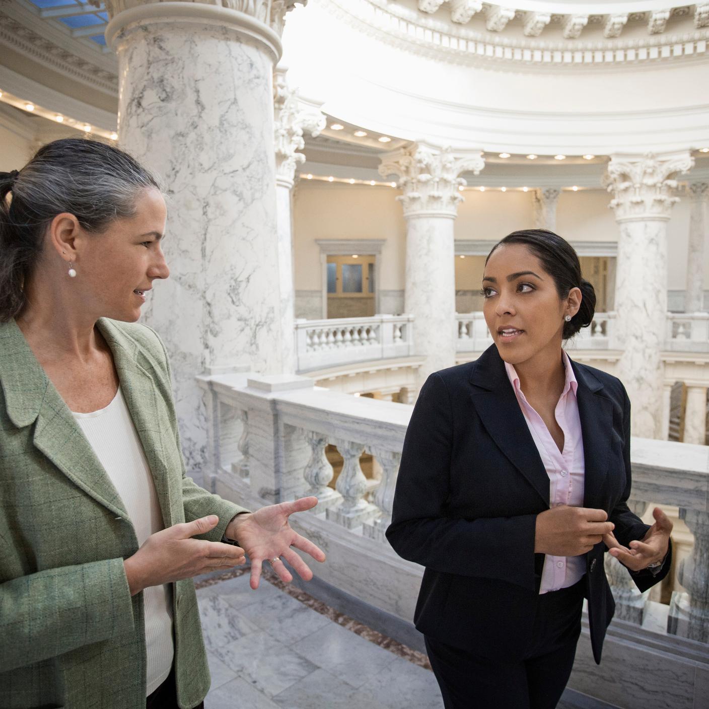 Two people walking inside a building having a discussion