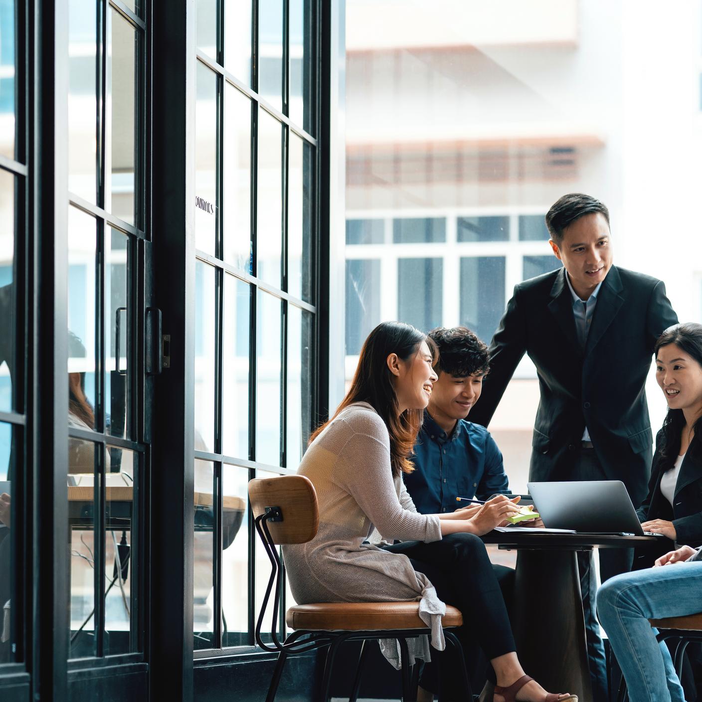 A group of five people having a meeting in an office
